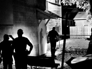 Several police officers search a house for an armed suspect in Northeast Rochester. Rochester, NY. USA 2012